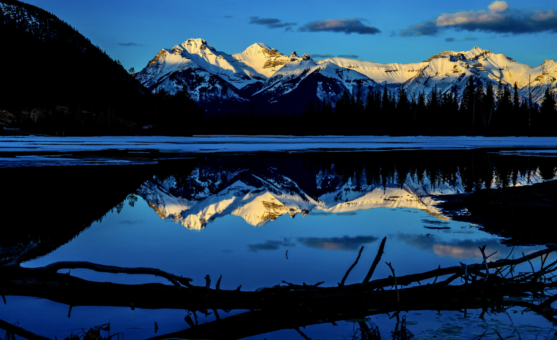 Snow-covered Alberta mountains reflected in a lake